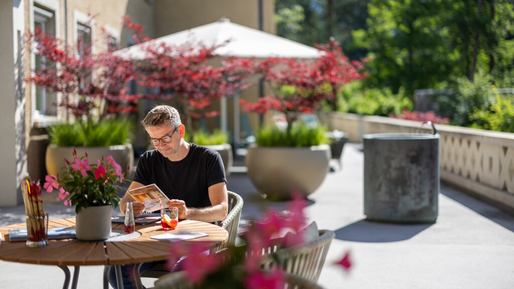 Person beim Lesen auf der Terrasse der MENTALVA