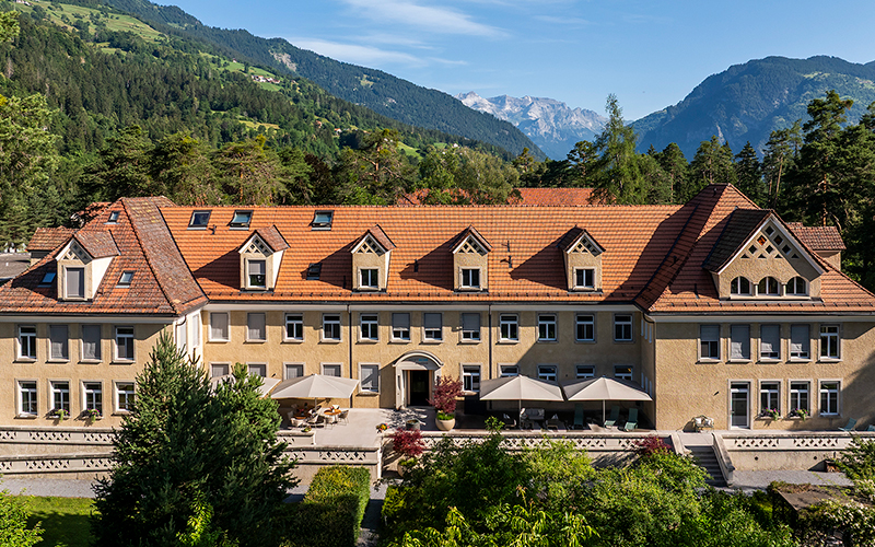 Klinikgebäude der MENTALVA mit Berglandschaft im Hintergrund