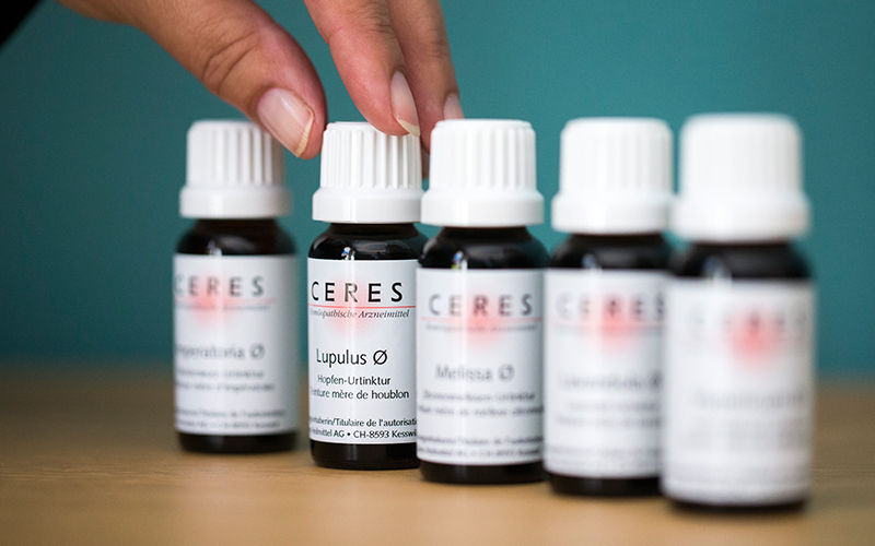 Kleine Flaschen mit Tropfen-Arzneimitteln auf einem Tisch