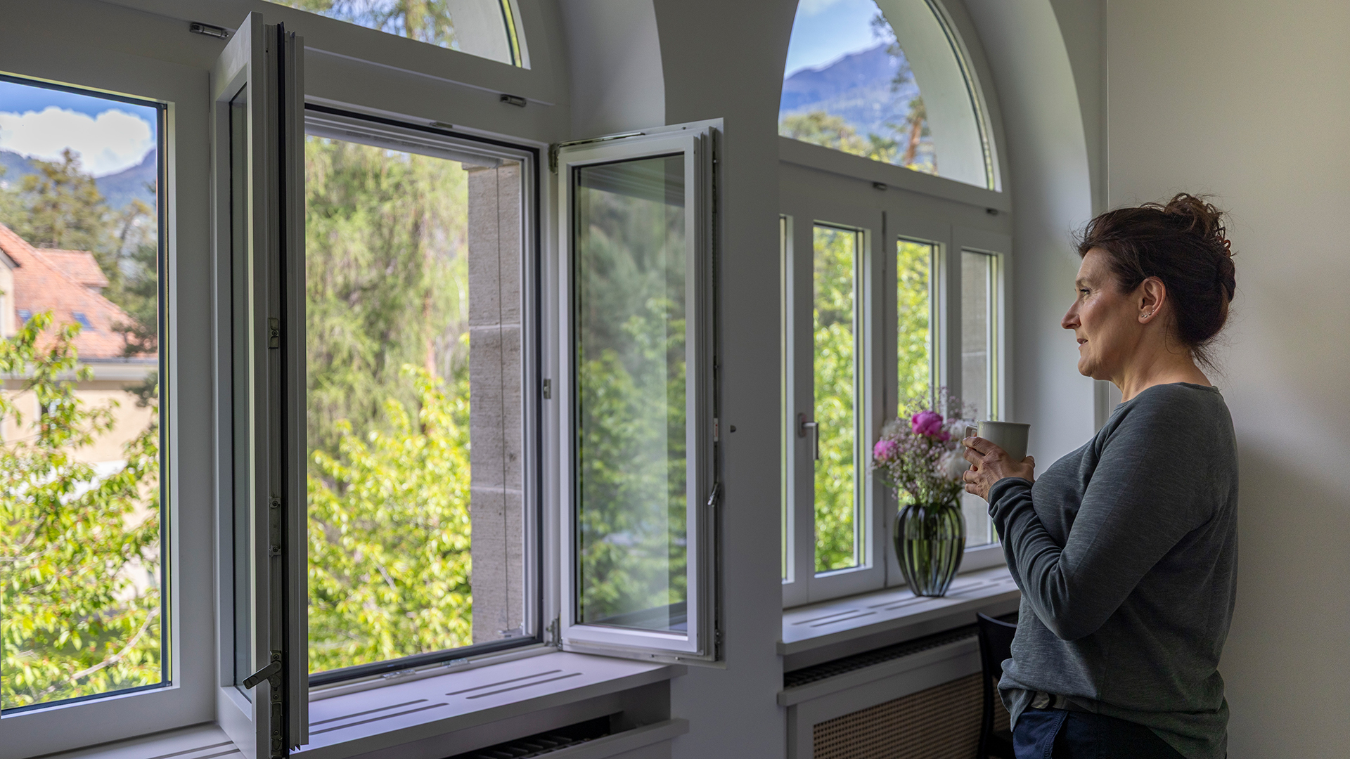 Person blickt aus dem Fenster der MENTALVA ins Grüne