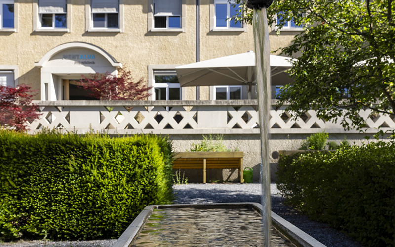 Blick auf Klinikeingang der Privatklinik MENTALVA vom Garten aus